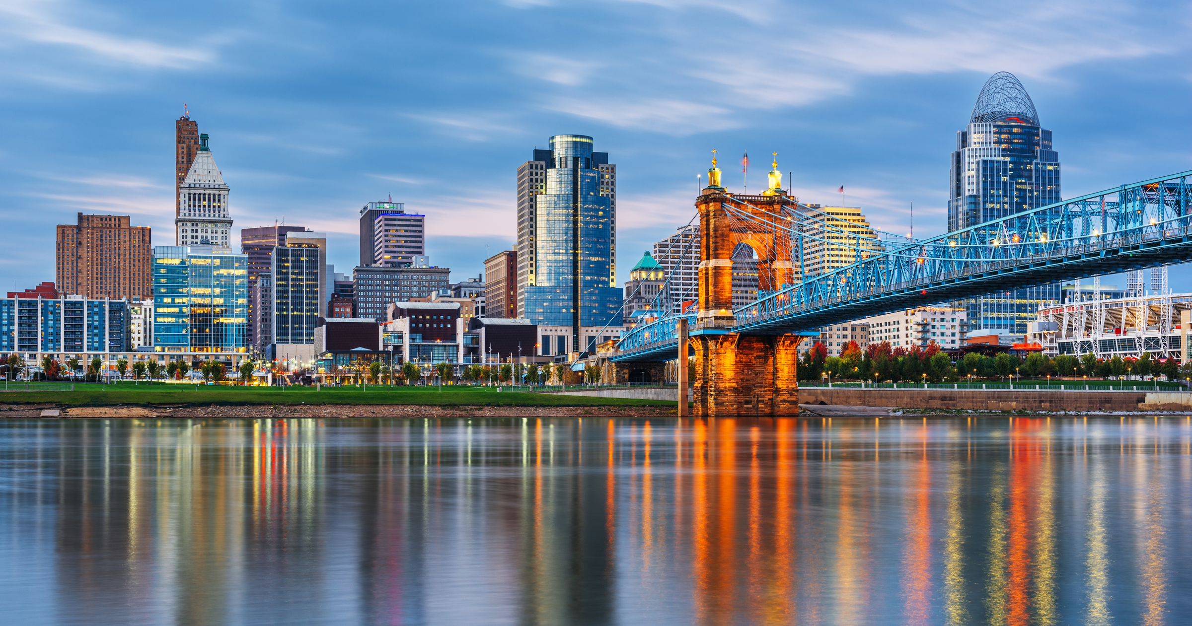 Cincinnati, Ohio, USA downtown skyline and bridge on the river at dusk.