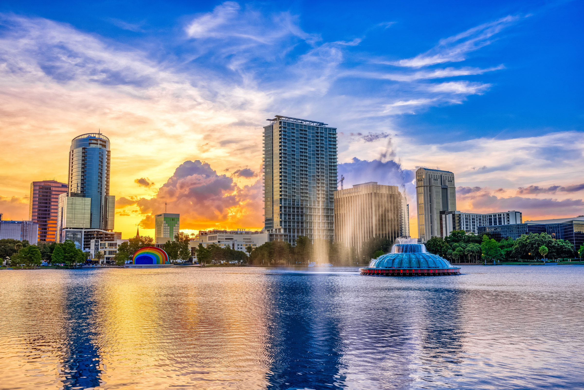 ORLANDO FL, US - May 24, 2022: Sunset and clouds over the Orlando skyline and fountain at Lake Eola Park, Orlando FL