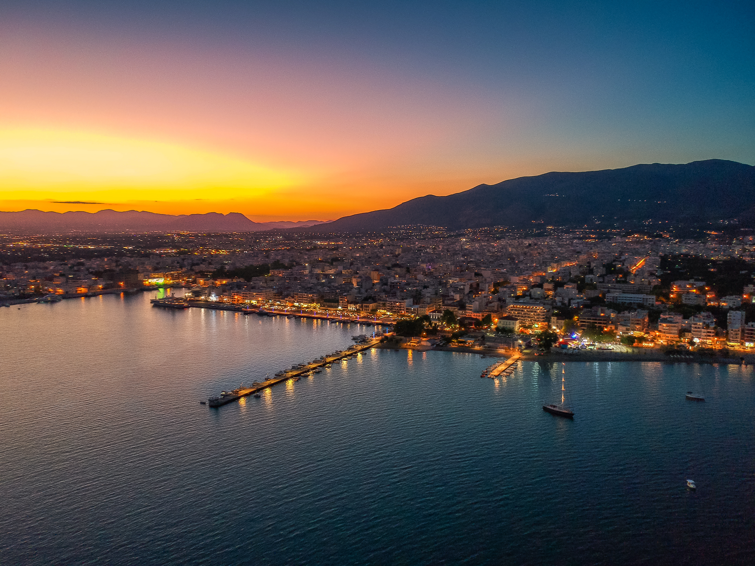 Aerial cityscape view of the Beautiful coastal city of Kalamata and the port at night. Kalamata is the capital and the second largest city in the Peloponnese, Greece, Europe.