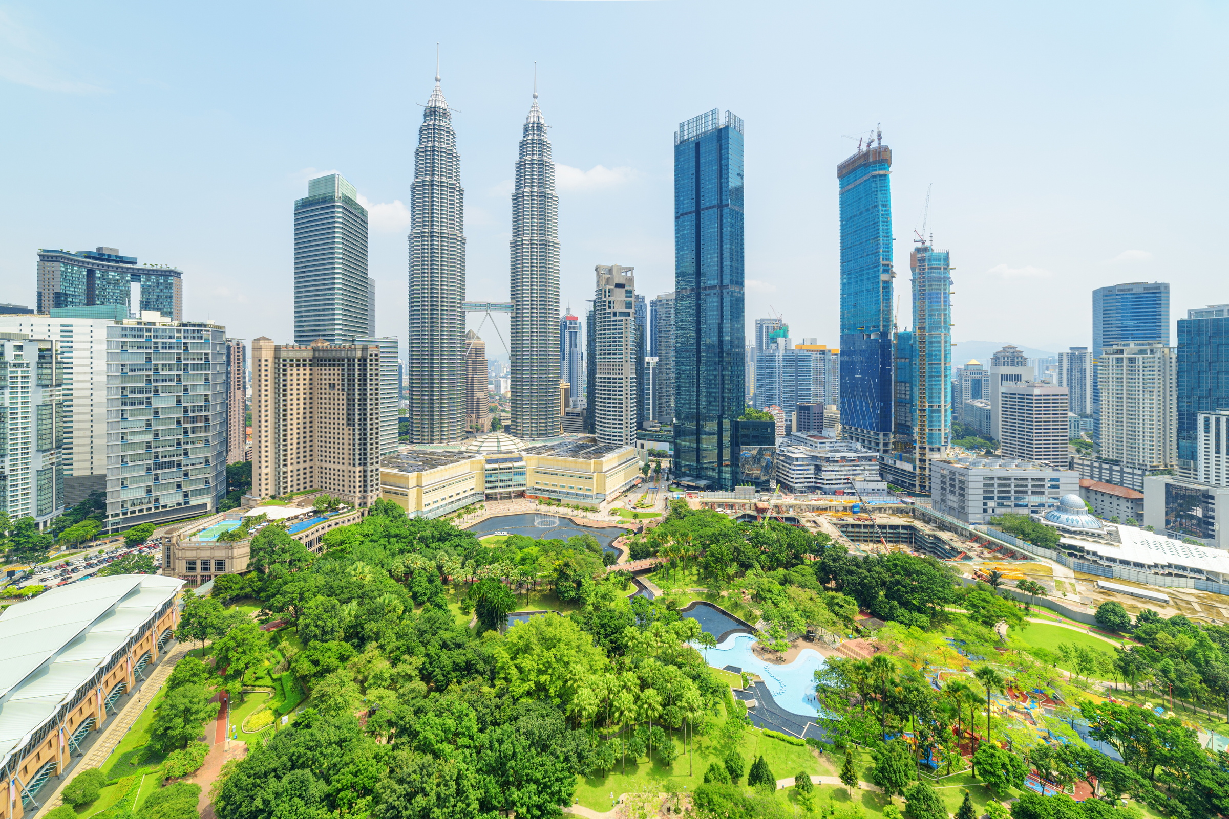 Aerial view of the KLCC Park and the Petronas Twin Towers in Kuala Lumpur, Malaysia. The urban park in Kuala Lumpur City Center is a popular tourist attraction of Asia. Awesome Kuala Lumpur skyline.