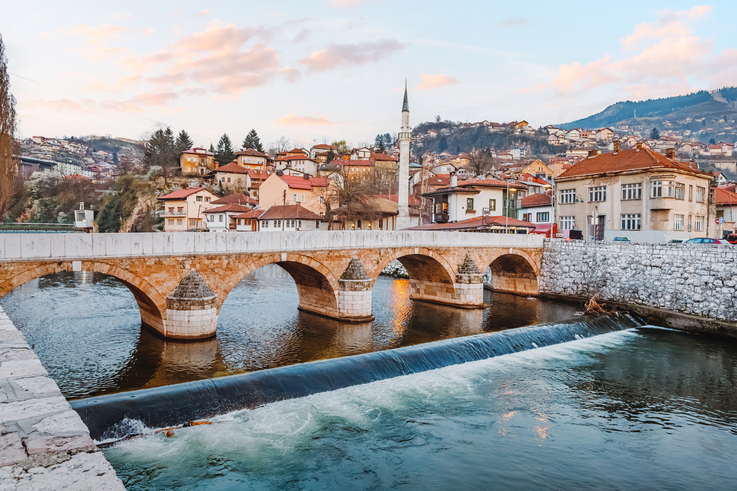 A picturesque scene of Sehercehaja Bridge spanning the river in Sarajevo, Bosnia