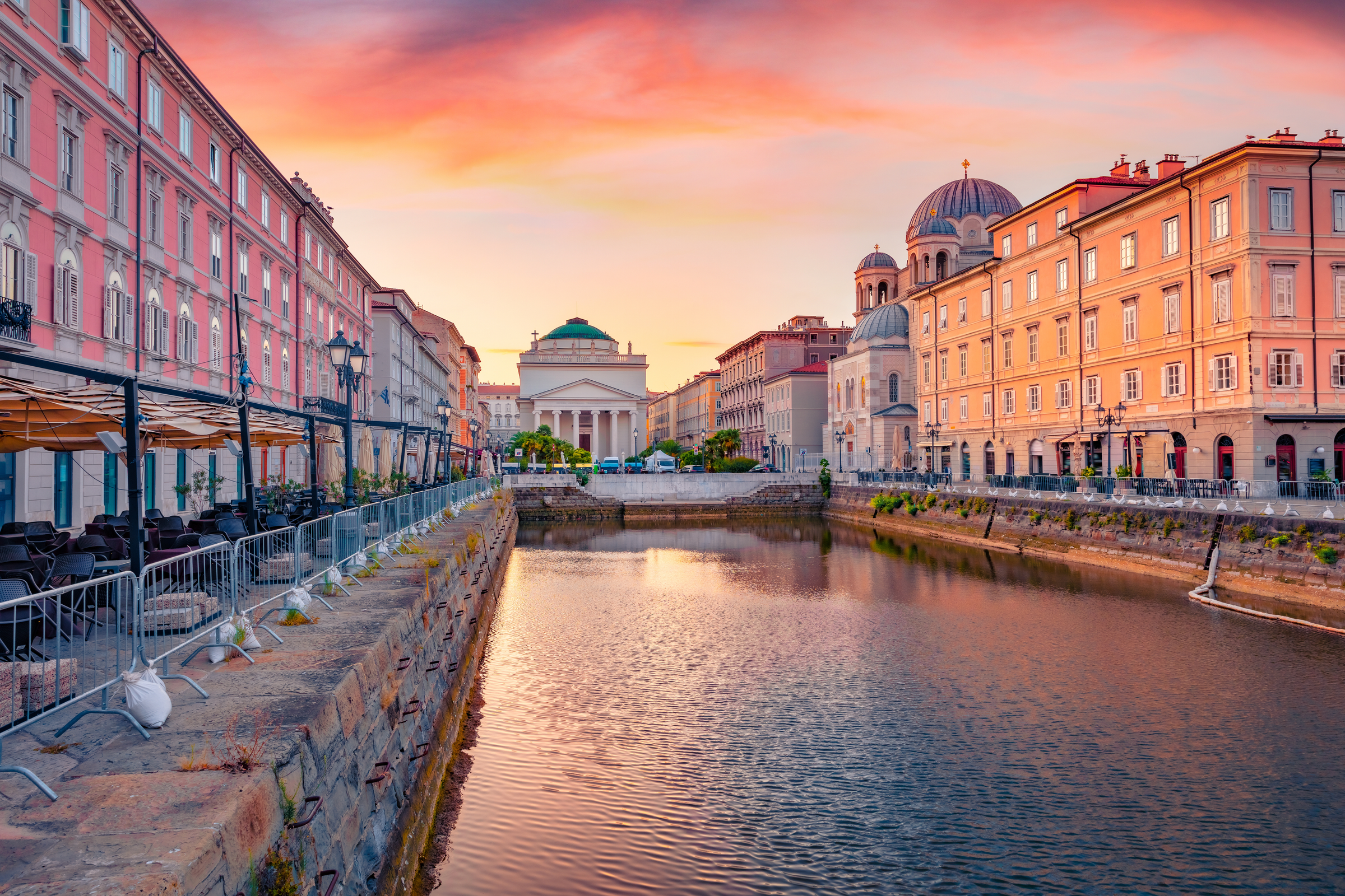 Spectacular summer sunrise in Trieste, Italy, Europe. Gorgeous morning view of Canal Grande di Trieste and Church of Sant'Antonio Nuovo on background. Traveling concept background.