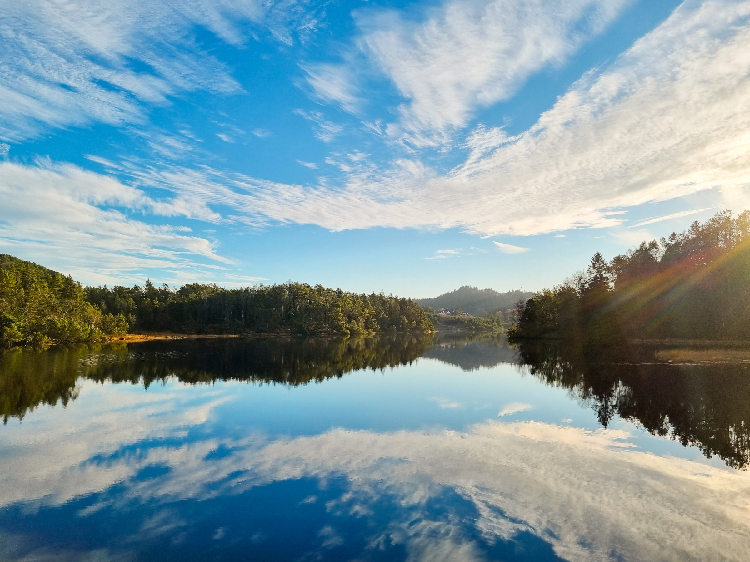 A sky full of beatuiful clouds over still water. Picture taken in Djupadalen, in Haugesund, Norway. Reflection of skies in water.