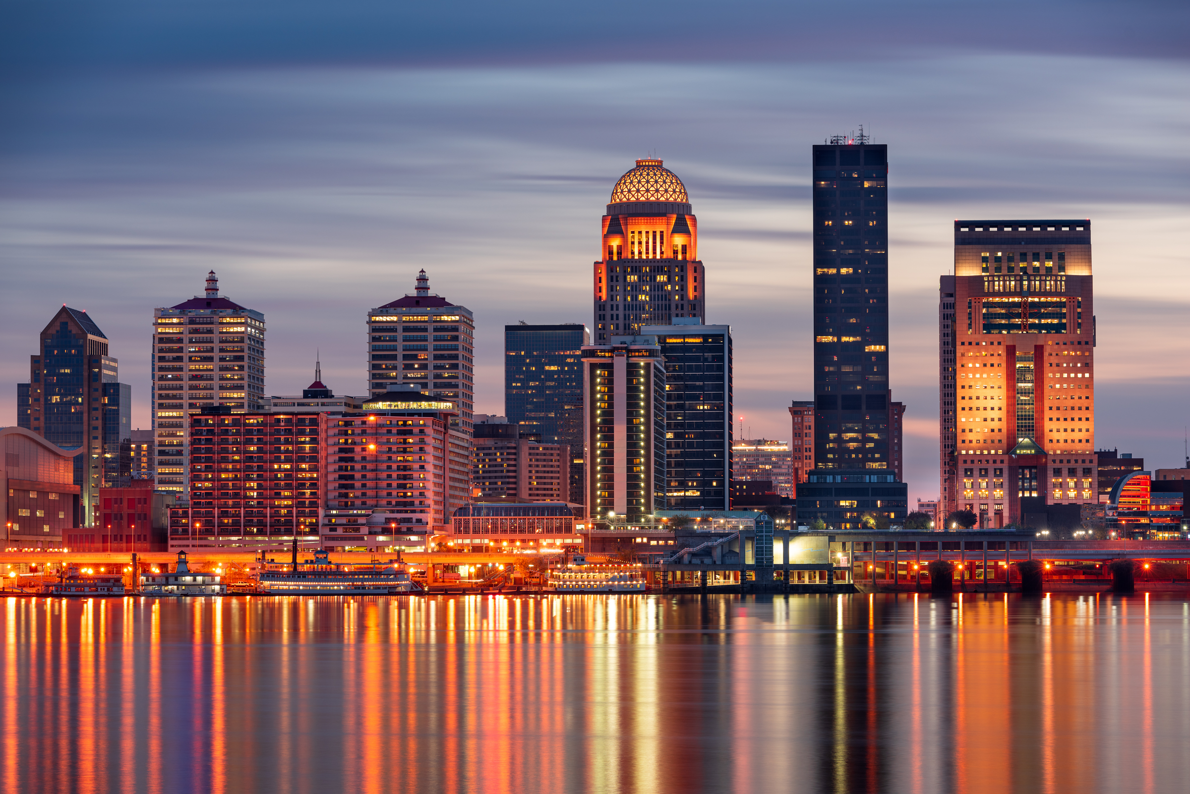 Louisville, Kentucky, USA skyline on the Ohio River at night.