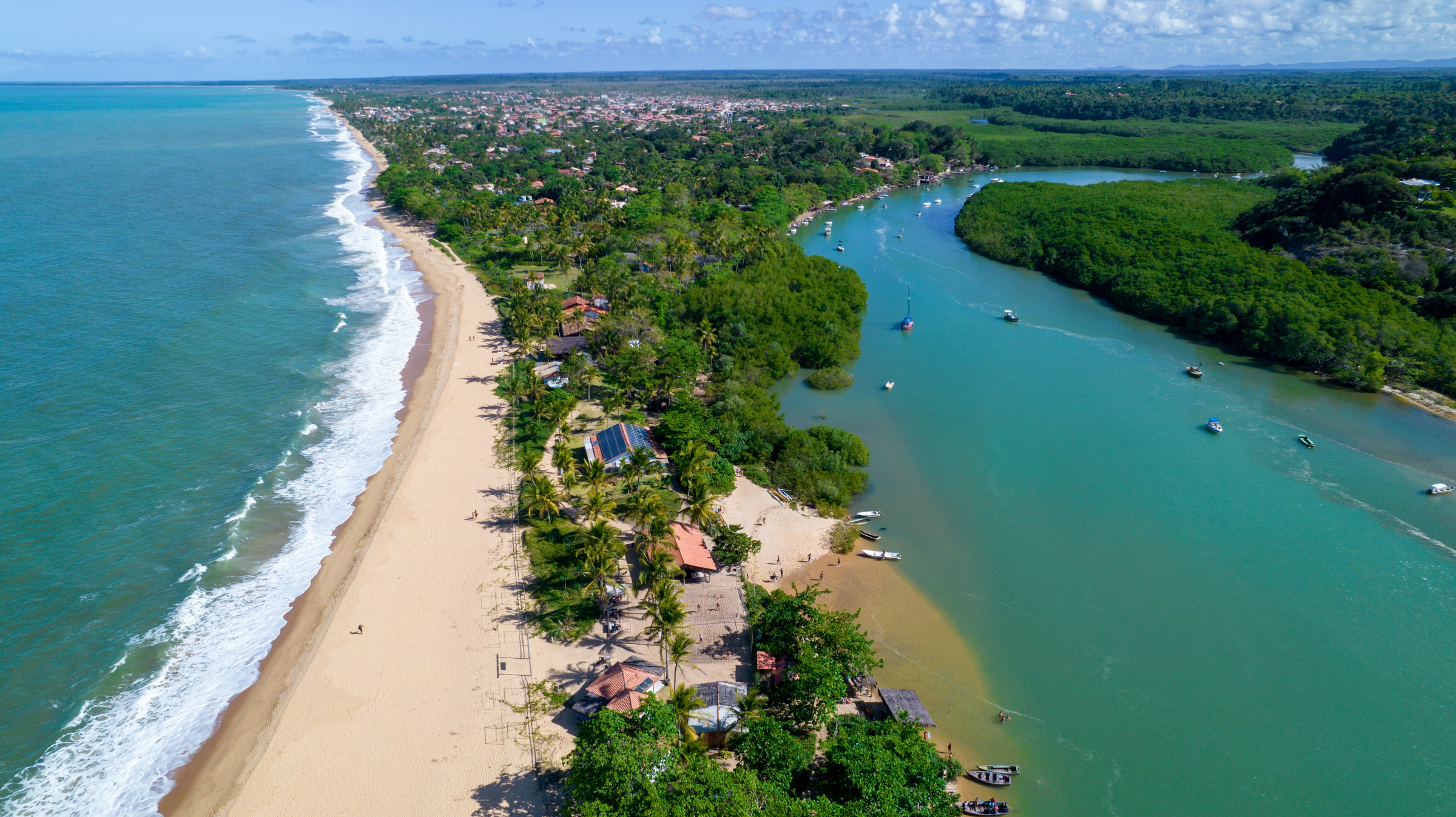 Aerial view of Caraiva beach, Porto Seguro, Bahia, Brazil. Colorful beach tents, sea and river.