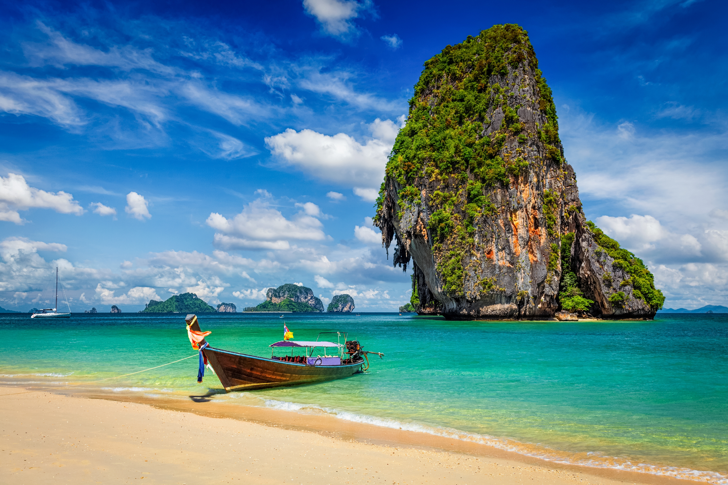 Thailand tropical vacation concept background - Long tail boat on tropical beach with limestone rock, Krabi, Thailand