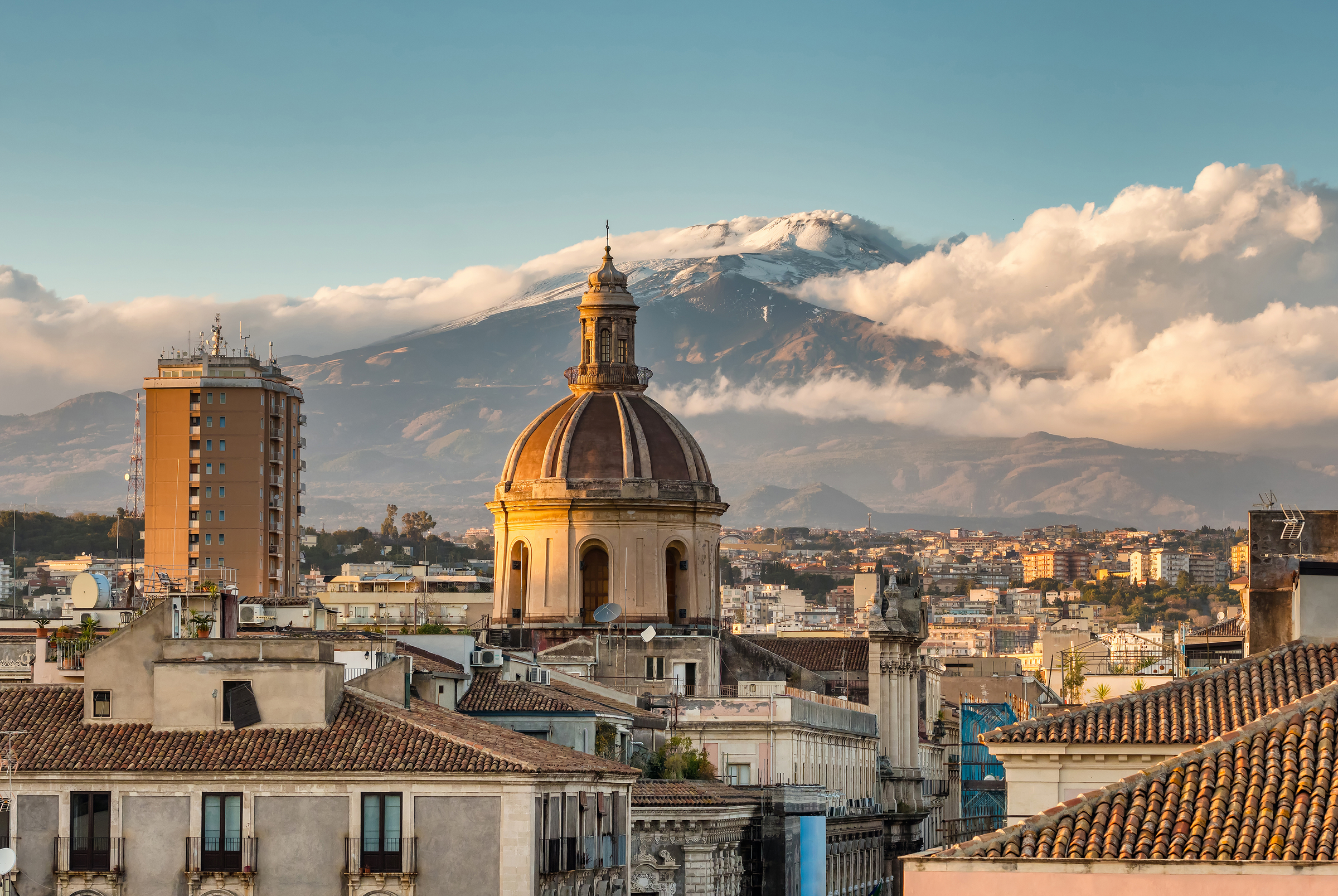 Catania cityscape with the view of Etna volcano at sunset in Sicily, Italy. Catania downtown top view with majestic Etna at background