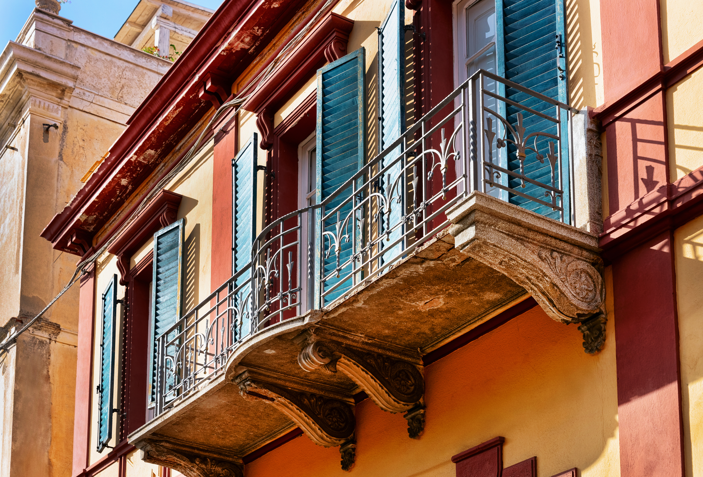 Old Apartment house residential home architecture with outdoor facilities. Windows with shutters and balconies in city of Olbia on Sardinia Island in Italy.